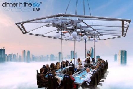 Aerial view of the Dinner in the Sky dining platform suspended over Dubai with guests seated.